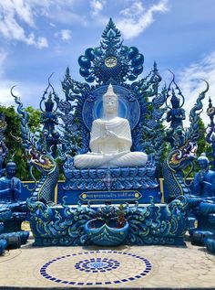 a buddha statue sitting on top of a blue bench