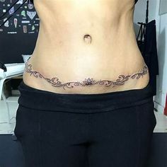 a woman's stomach with an intricate tattoo on her lower back and side view