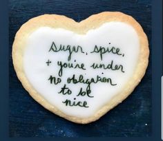 a heart - shaped cookie with writing on it that says sugar, spice and you're under no origin to be nice