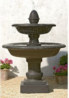 an outdoor fountain with flowers in the background