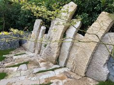 several large rocks sitting next to each other on top of a grass covered park ground