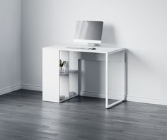 a white desk with a computer monitor and keyboard on it in front of a wall