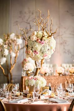 the centerpieces are adorned with flowers, branches and glass vases for an elegant touch