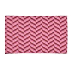 a pink place mat with wavy lines on the front and back of it, against a white background