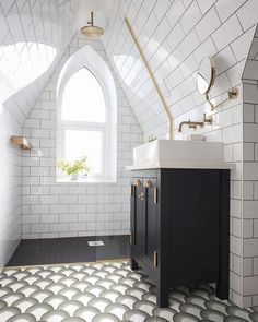 a bathroom with white and black tile flooring next to a large window on the wall