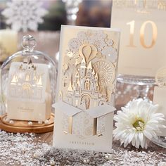 a table topped with lots of white cards and paper cut decorations on top of it