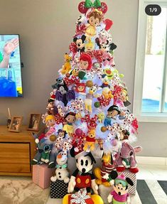 a mickey mouse christmas tree with lots of disney characters on it's top and bottom