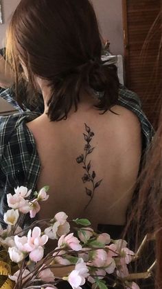 a woman with a flower tattoo on her back