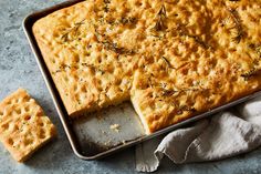 a baking pan filled with crackers next to a piece of bread on top of a napkin