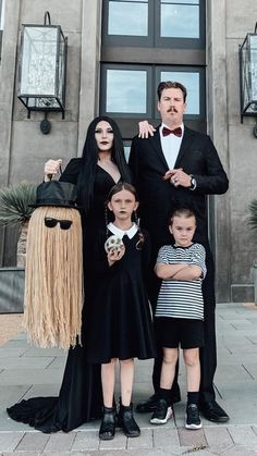 a family dressed up for halloween standing in front of a building