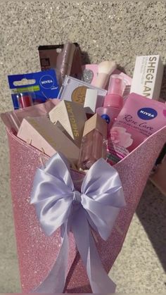 a pink gift bag filled with lots of beauty and personal care items on top of a table