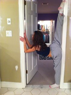 a woman standing on one leg in front of a door