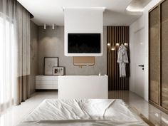 a white bed sitting in a bedroom next to a tv mounted above it's headboard