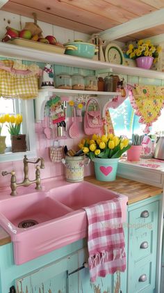 a pink kitchen sink sitting under a window next to a counter top with yellow flowers