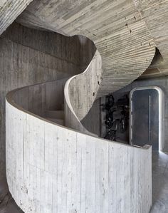 a curved concrete staircase in the middle of a building