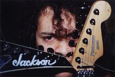 a man holding a guitar in front of his face with the words jackson on it