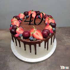 a chocolate cake with strawberries and blueberries in the shape of a number forty