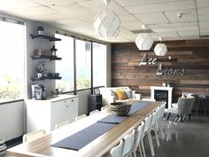 a dining room table and chairs in front of a wall with wood planks on it