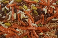 carrots, raisins and seeds are mixed together in a mixture on top of rice