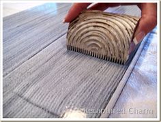 a person is using a brush to clean the wood grains on a wooden floor