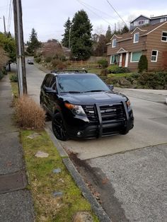 a black suv is parked on the side of the road