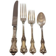 four forks and two spoons with ornate designs