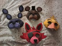 four animal masks laid out on a bed