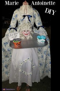 a woman dressed in white holding a tray with cupcakes and cake on it