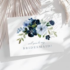 a white card with blue flowers and the words will you be my bridesmaid?