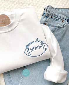 Game day Football Shirt, Embroidered Football Game Pullover, Football Season Womens Football Shirt, Football Game Day Sweatshirt, Fall Shirt ---HOW TO ORDER---   FOR EACH SHIRT CHOOSE: **Shirt type, size and color (shirt shown is white with #24  thread) ---UNISEX SIZING--   Please see size chart in the pictures ---PRODUCT DETAILS--- Gildan Crewneck UNISEX Sweatshirt 50% cotton, 50% polyester Pre-shrunk Air jet yarn for softer feel and reduced pilling Double-needle stitched collar, shoulders, arm Cute Football Sweatshirts, Charger Football Game Outfit, Sweatshirt Designs Embroidery, Football Sweater Ideas, Sports Cricut Projects, Football Shirts For Women, Football Embroidered Sweatshirt, Trendy Embroidered Sweatshirt, Trending Sweatshirt Designs