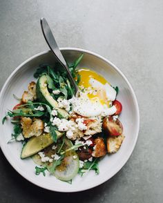 a white bowl filled with vegetables and eggs