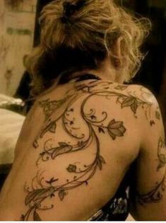 a woman with tattoos on her back