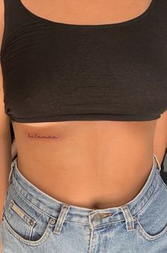 a woman's stomach with the word love tattooed on it