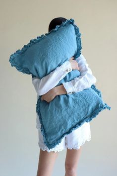 a woman is holding two pillows on her back