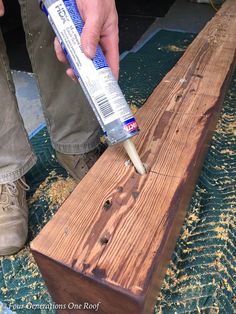 a person is using glue to paint wood planks with blue and white adhesivement