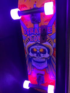 a skateboard is lit up with purple lights and the image of a skull on it