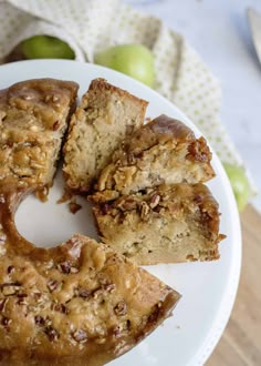 a white plate topped with pieces of cake next to an apple pie on top of a wooden table