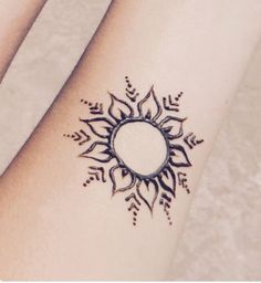 a woman's arm with a tattoo design on it, showing the sun and arrows