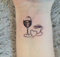 a woman's foot with a wine glass and heart tattoo on it