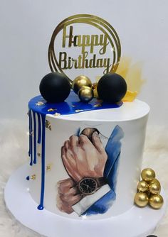 a birthday cake decorated with an image of a man's hand and gold balls