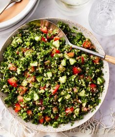 a salad with cucumbers, tomatoes and other vegetables in a bowl on a table