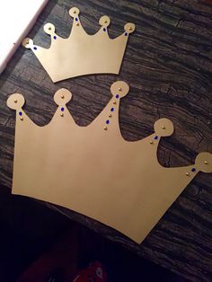 a cardboard crown cut out on top of a wooden table next to a pair of scissors