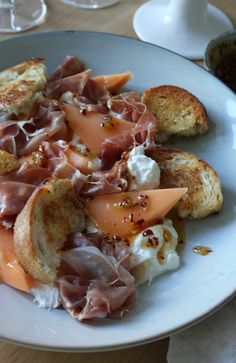 a white plate topped with meat and bread