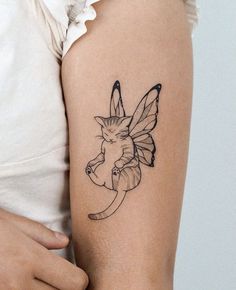 a woman's arm with a small tattoo of a cat sitting on the moon