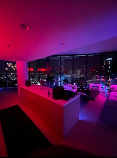 a living room filled with furniture next to a large window covered in bright purple lights