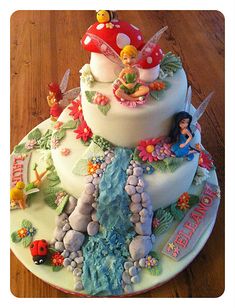 a three tiered cake decorated with fairy tale characters