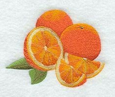 three oranges with green leaves on white towel