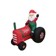 an inflatable santa clause riding a toy tractor