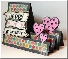 two hearts are placed on top of each other in front of an anniversary card holder