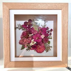 a bouquet of flowers in a wooden frame